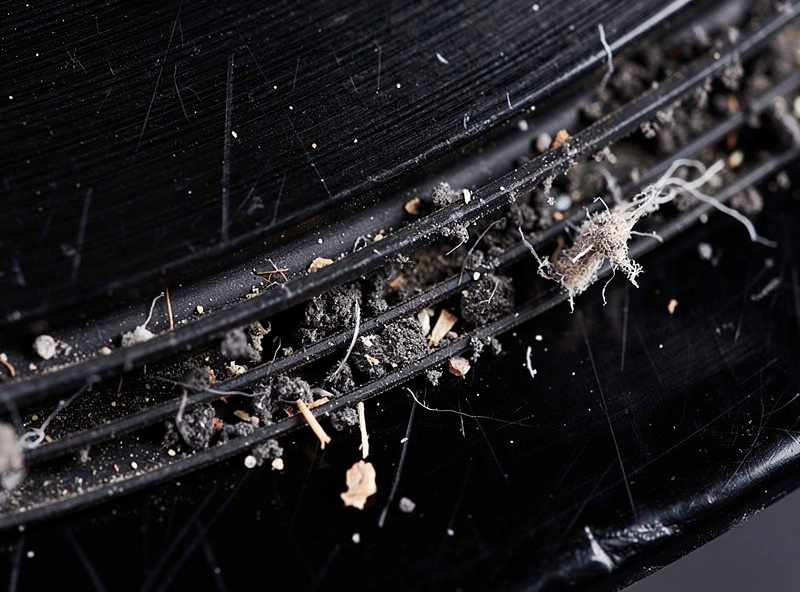 Close-up of a vinyl record surface showing dust particles caught in grooves