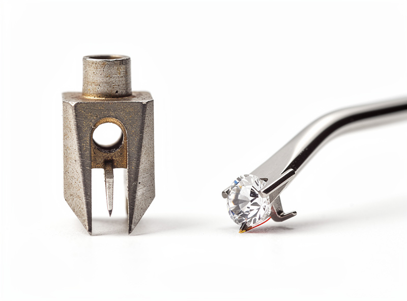 Close-up of steel phonograph needle next to modern diamond stylus showing size difference