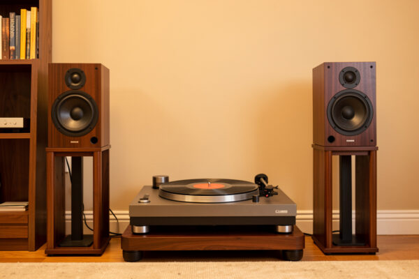 Bookshelf speakers on stands flanking a turntable in a vinyl listening room