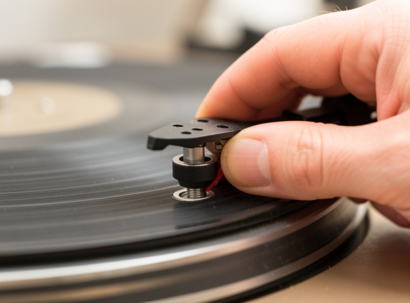 Fingers checking a vintage turntable tonearm bearing for play at the gimbal