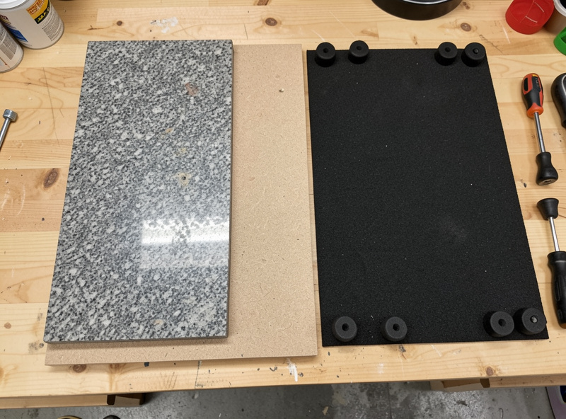 Materials for a DIY turntable isolation platform laid out: MDF, granite, damping sheet, and feet