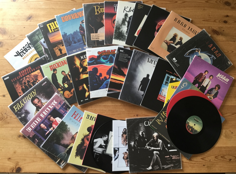 A varied vinyl collection spanning multiple genres fanned out on a table