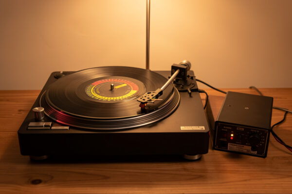 Belt-drive turntable with external speed controller and a strobe disc on the platter
