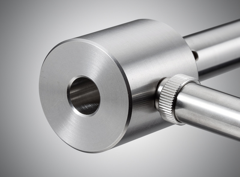Telescope counterweight on equatorial mount shaft, precision-machined metal with locking thumbscrew, observatory equipment detail