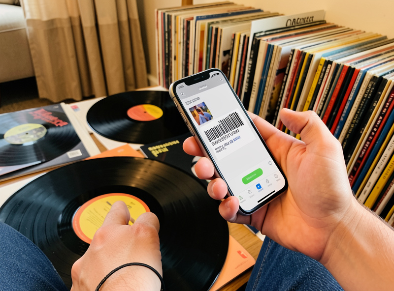 A person scanning a vinyl record barcode with a cataloging app on a phone
