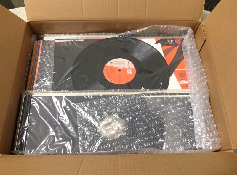 Bubble wrap lining the bottom of a box with records being packed in