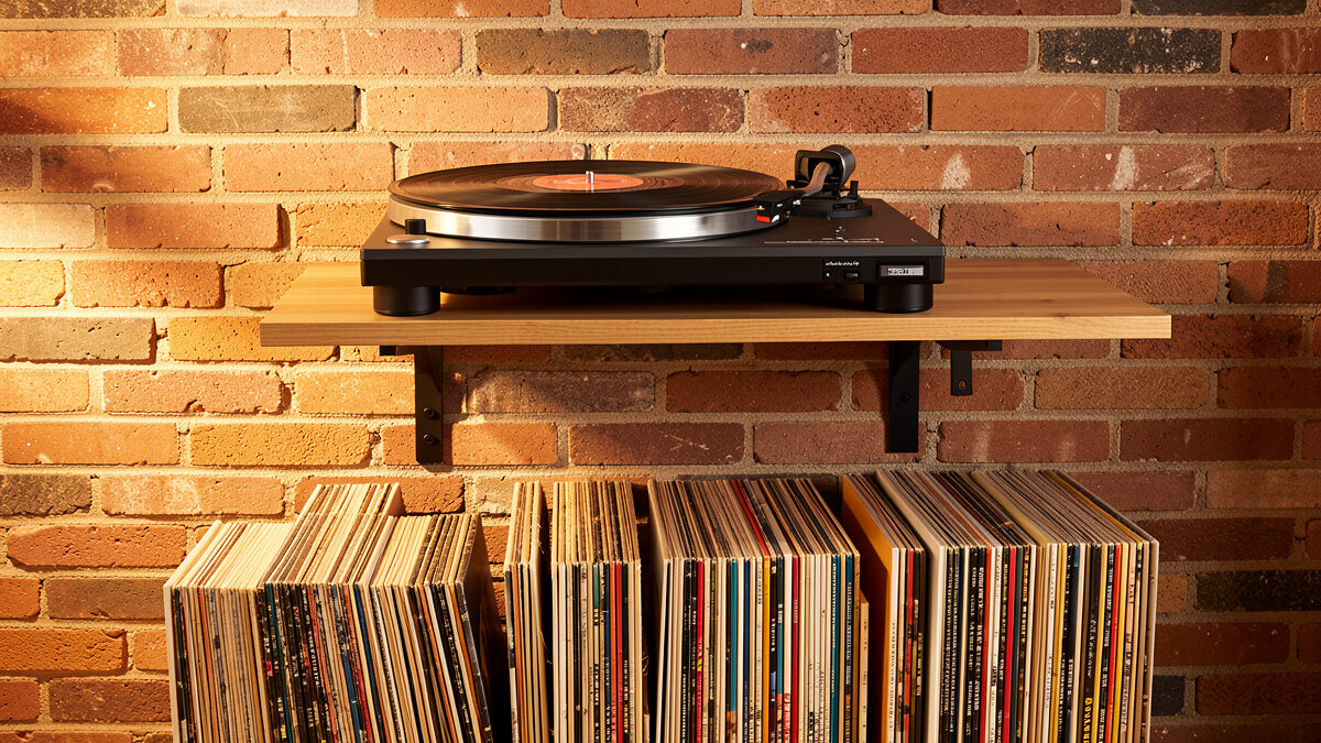 Turntable on a wall-mounted isolation shelf above a record collection