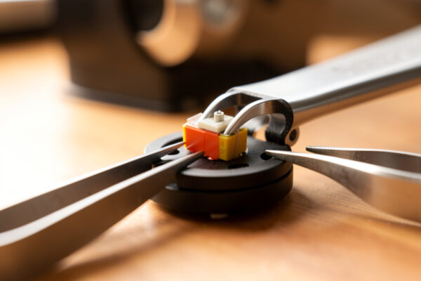 Thin shim spacers placed between a phono cartridge and a headshell to set vertical tracking angle