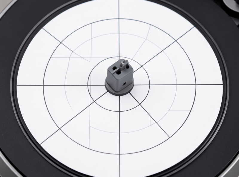 Two-point cartridge alignment protractor on a turntable platter with the cartridge aligned over a null point
