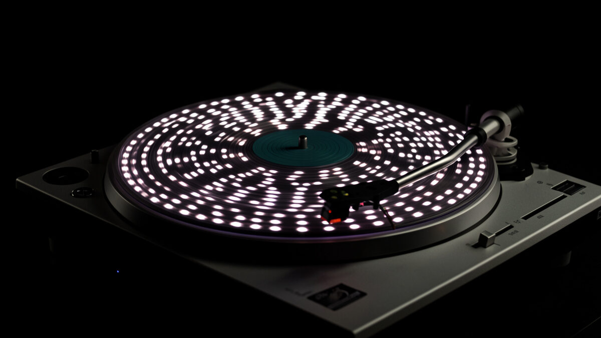 A strobe disc spinning on a portable turntable platter under a strobe light showing speed-check dots