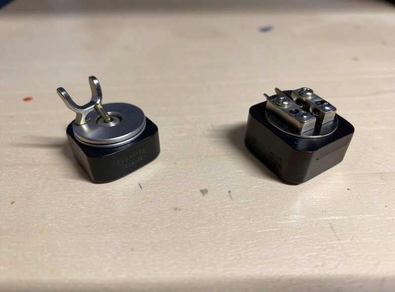A moving coil cartridge with a bonded cantilever next to a moving magnet cartridge with a removable stylus