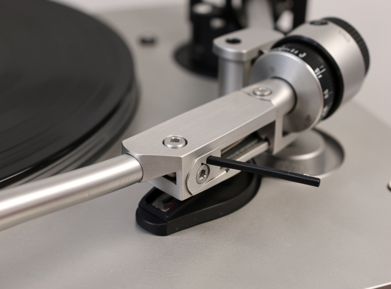 Close-up of a turntable tonearm counterweight and adjustable dial at the back of the arm
