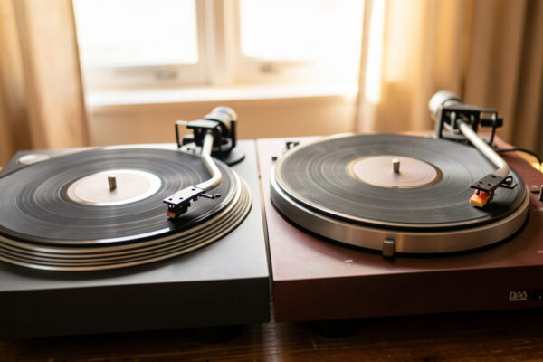 A turntable with a removable S-shaped bayonet headshell beside one with a fixed integrated Rega-style arm