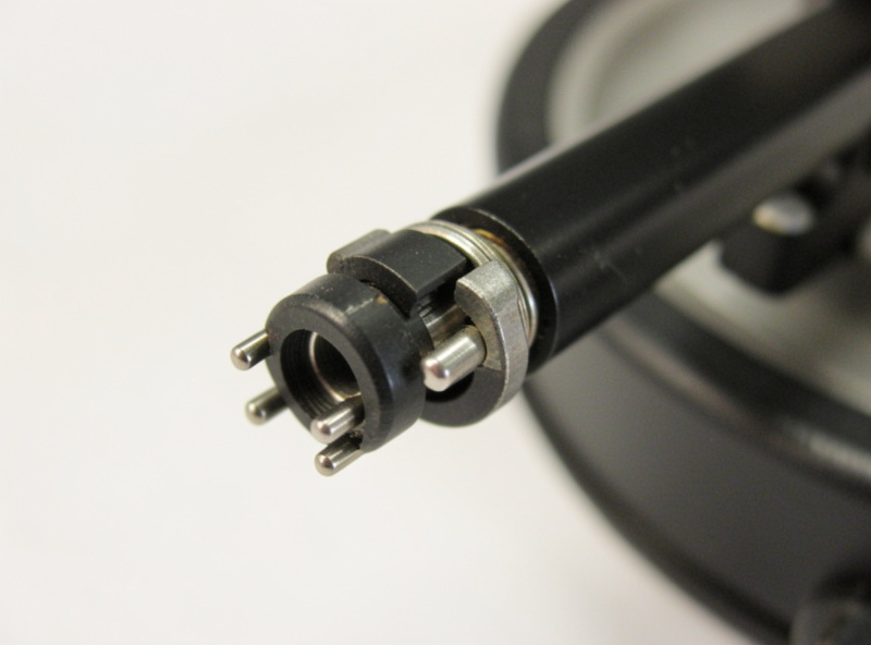 Universal bayonet headshell collar being twisted to lock onto a tonearm with four pins visible