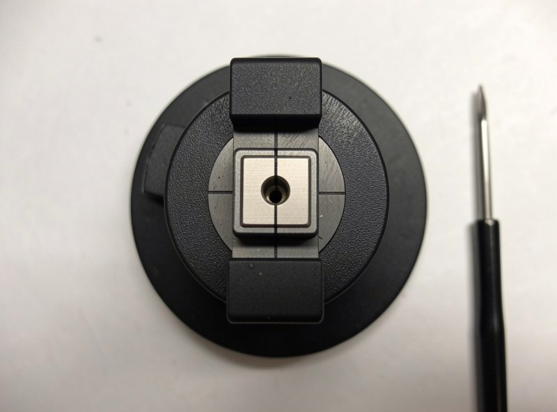 Phono cartridge squared precisely in a headshell during alignment with an alignment tool nearby